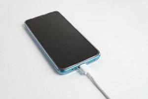 blå mobiltelefon ansluten till usb -kabel typ c - laddning