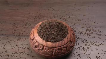 svart tepulver eller torrt tepulver, chai patti isolerat i träskål. foto