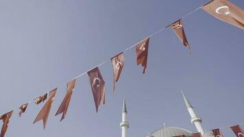 Kalkon, istanbul-december, 2020. turkiska flaggor på blå himmel bakgrund. handling. festlig band med turkiska flaggor fladdrande i vind. turkiska flaggor hänga på festlig rep på bakgrund av minareter foto