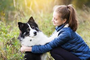 söt tjej som sitter framför sin hund foto