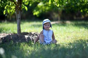 vacker baby pojke i barn trädgård poserar fotograf foto