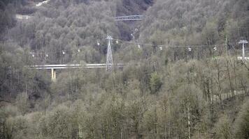 topp se av kabel- bil över bro. kabel- bil passerar genom vild skog utanför stad i höst. berg skog område med broar och kabel- bil foto