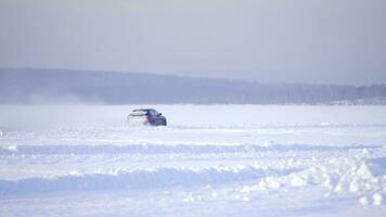 körning i de snö. vinter- bil spår på snöig strand. körning en lopp bil på en snöig väg. Spår vinter- bil tävlings med Sol reflexion. lopp på de Spår i de vinter- foto