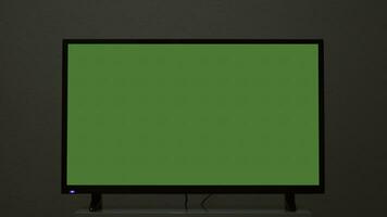 plasma TV med grön skärm står på bakgrund vägg. begrepp. grönskärm TV står på bakgrund grå vägg. grön skärm TV för införing Chromakey foto
