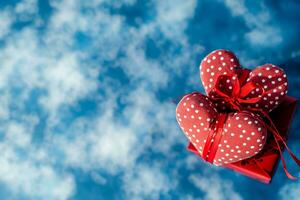 ai genererad röd gåvor med reste sig blommor på blå molnig bakgrund, Lycklig valentine dag begrepp foto