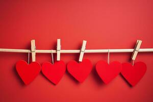 ai genererad röd hjärtan hänga på trä- kläder pinnar på röd Färg bakgrund, Lycklig valentine dag begrepp foto