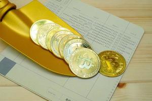 närbild av guld bitcoin mynt på bank passbook med en gyllene spade på träbord foto