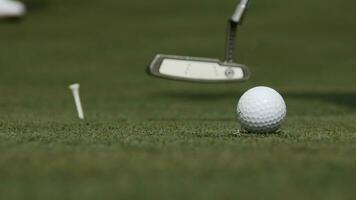 professionell golfspelare sätta boll in i de hål. golf boll förbi de kant av hål med spelare i bakgrund på en solig dag foto