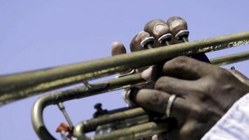 detalj av en mannens händer spelar en trumpet. handling. närbild av en svart mannens händer spelar de trumpet foto