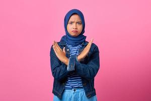 porträtt av arg ung asiatisk kvinna som är allvarligt missnöjd med att visa korsade stopp gest foto
