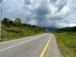 asfalt motorväg väg i de karpater bergen med tung moln ovan. foto