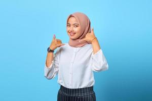 porträtt av attraktiv glad ung asiatisk kvinna gör telefon gest med handen foto