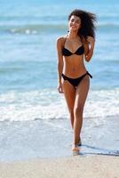 ung arabisk kvinna med vacker kropp i badkläder leende på en tropisk strand.