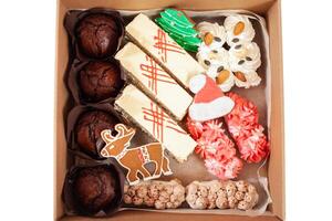 gåva låda för jul. leverans av mat till de hus för de ny år. pepparkaka, muffins och kakor. en rådjur, en träd och jultomten hatt. foto