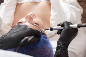 de kosmetolog utför de mikroström procedur i de skönhet salong. foto