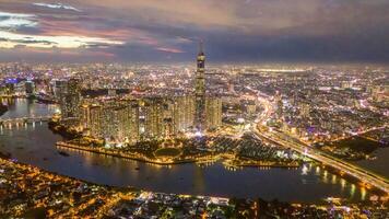 antenn solnedgång se på landmärke 81 - den är en super lång skyskrapa och saigon bro med utveckling byggnader längs saigon flod, stadsbild i de natt foto