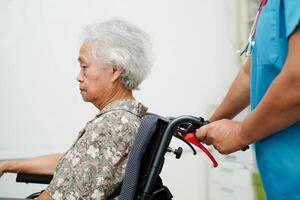 läkare hjälp asiatisk äldre kvinna handikapp patient Sammanträde på rullstol i sjukhus, medicinsk begrepp. foto