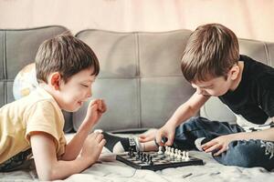 Pojkar spela schack. barn spela schack på Hem. rivaler. tid utan telefoner. dess en tid tillsammans. foto