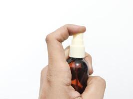 fingrar innehav eller gripande en spray flaska isolerat på en vit bakgrund foto