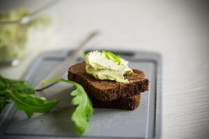 bröd ost spridning med vitlök och arugula på mörk bröd foto