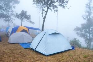 tält camping på campingplats torr äng på topp berg med dimmig foto