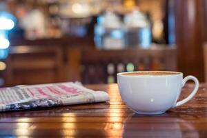 varm espresso kaffe kopp med tidning på trä- tabell belysning bokeh fläck bakgrund foto