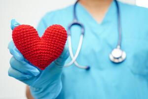 asiatisk kvinna läkare håller rött hjärta för hälsa på sjukhus. foto
