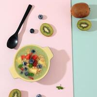 topp se kiwi smoothie med jordgubbe, granola, och blåbär garnering foto