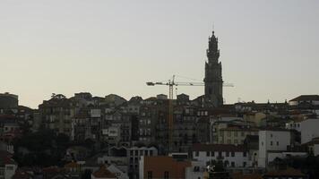 Portugal, porto - juli 17, 2022. torn höga över gammal stad. handling. skön landskap av gammal stad med röd tak och hög torn. clerigos kyrka torn är symbol av stad av porto foto