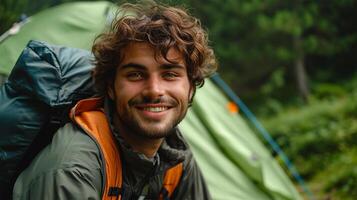 ai genererad porträtt av leende man med ryggsäck stående i främre av camping tält foto