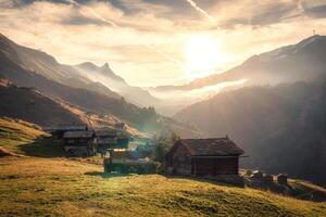 soluppgång över berg och rustik by, lastbil på kulle i landsbygden på schweiz foto