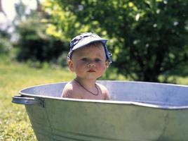 vacker baby pojke i barn badkar poserar fotograf foto