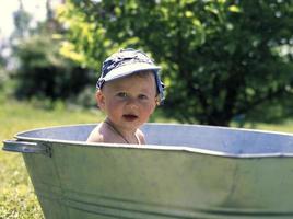 vacker baby pojke i barn badkar poserar fotograf foto