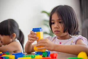 bedårande liten flicka spelar leksaksblock i ett ljust rum foto