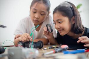 uppfinningsrik barn lära sig på Hem förbi kodning robot bilar och elektronisk styrelse kablar i stam. konstruera robot bilar på Hem foto