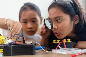 uppfinningsrik barn lära sig på Hem förbi kodning robot bilar och elektronisk styrelse kablar i stam. konstruera robot bilar på Hem foto