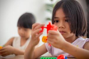 bedårande liten flicka spelar leksaksblock i ett ljust rum foto