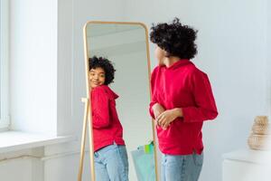 kärlek själv. skön ung leende afrikansk amerikan kvinna dans njuter henne spegel reflexion. svart lady ser på spegel ser självsäker och Lycklig. själv kärlek begrepp foto