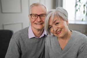 senior vuxen mogna par kramas på Hem. mitten ålder gammal Make och fru fattande med ömhet kärlek njuter ljuv bindning välbefinnande. mormor farfar tillsammans. familj ögonblick kärlek och vård foto