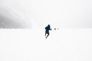 ung person som hoppar i luften i ett vinterlandskap med snö. frysta lake louise, banff nationalpark, Kanada foto