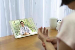 senior kvinna konsultera asiatisk läkare online foto