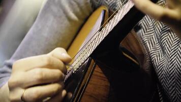 närbild skön akustisk gitarr varelse spelade förbi kvinna Sammanträde ner, musiker begrepp. kvinna spelar de gitarr närbild foto