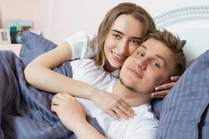 kärleksfullt vackert par i sängen på morgonen, kärleksfull familj - heterosexuellt par foto