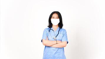 ung asiatisk kvinna läkare använder sig av medicinsk mask innehav vapen och ser på kamera isolerat på vit bakgrund foto