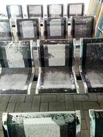 flera rader av svart väntar stolar, tillverkad av rostfri stål, de måla är lite urblekt, under de dag foto