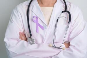 läkare med lila band för värld cancer dag, lupus, pankreas, esofagus, testikulär cancer, värld alzheimer, epilepsi, sarkoidos, fibromyalgi och inhemsk våld medvetenhet månad begrepp foto
