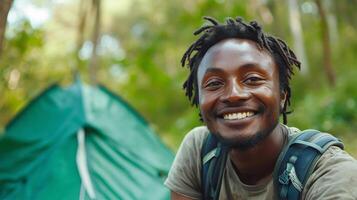 ai genererad porträtt av leende man med ryggsäck stående i främre av camping tält foto