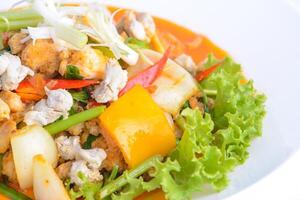 thai favorit mat. Vispa friterad bläckfisk med curry på de vit maträtt. foto