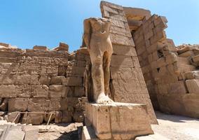fötter av en forntida staty av farao i karnak-templet i luxor foto