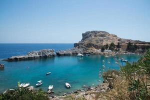 vacker bukt nära Lindos, Rhodos, Grekland. många båtar, blått vatten och solig dag foto